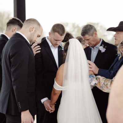 Wedding ceremony prayer and blessing moment under outdoor pavilion at Milagro Venue Texas